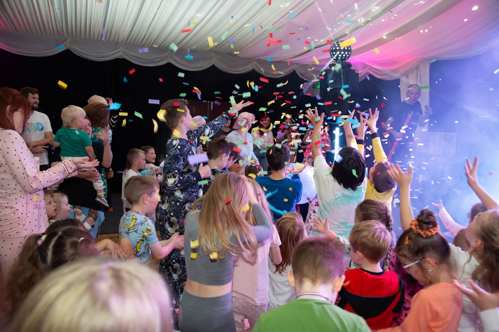 Little Dream Bug fundraiser party, children in pyjamas dancing under confetti